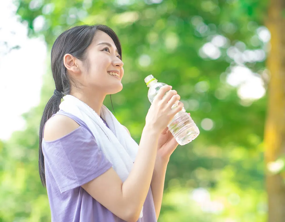 ペットボトルの水を飲む女性